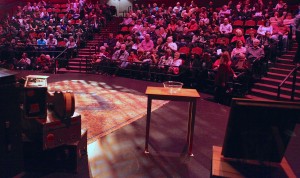 Audience seated in a theater for John’s performance